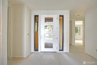 The entry welcomes you with a modern door front framed by glass panels creating a bright and inviting first impression.