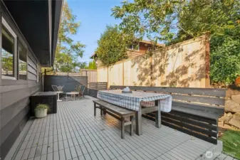 New fencing around backyard. Built in bench for dining, privacy screens, and plenty of foliage create an intimate space for hanging out.