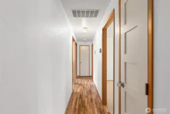 Well-designed hallway with two storage closets and a built-in AC panel, offering enhanced functionality and efficient home management