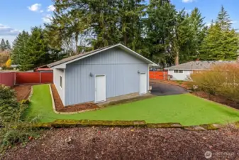 Beautifully maintained astroturf encircling the garage, combing year-round greenery, minimal upkeep, and enhanced curb appeal