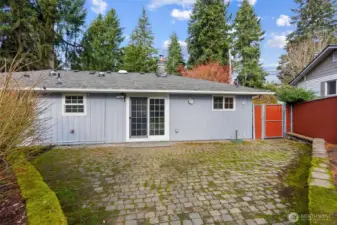Spacious stone back patio perfect for hosting gatherings, outdoor dining, and entertaining