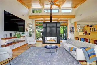 Living room looking toward the entry. Steel double sided gas fireplace....
