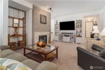 Elegant living room with gas fireplace with wood wainscoting above the fireplace.  Tile surround the fireplace