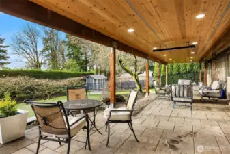 This fantastic stone patio enjoys a beautiful wood ceiling with lights and heaters for year round enjoyment.