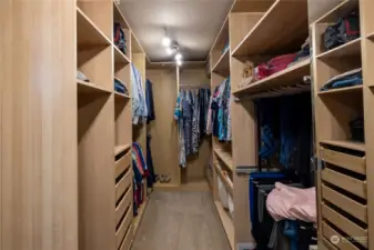 The walk in closet has a well organized design that has room for shoes and outfits galore.