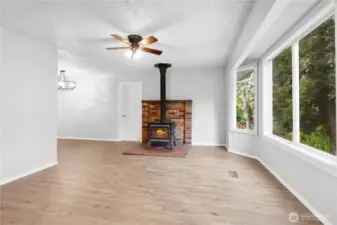 Living Room w/New Laminate Flooring, New Interior Paint, Ceiling Fan, Wood Stove w/Brick Surround.