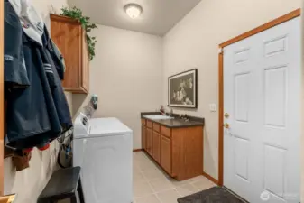 Main floor utility room with deep sink and plenty of storage for your laundry needs.