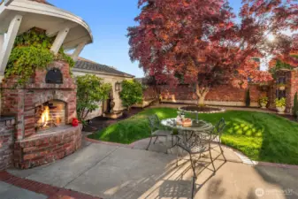 Step into the inviting backyard with old-world charm of a Tuscan villa, where dappled sunlight filters through mature maple trees. Ivy covered brick walls add privacy, making the patio with, BBQ grill,  the custom brick fireplace and pizza oven the perfect setting for sharing fine wine and memorable meals.