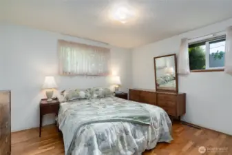 Primary bedroom with view of the back and side yard.  Hardwood floors.
