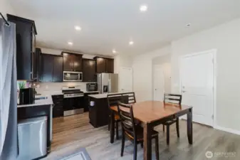 Dining area with modern lighting and views to the backyard.