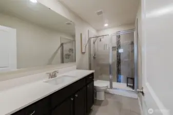 Primary bath with dual vanities and walk-in shower.