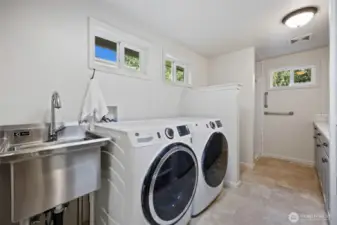 Just off the kitchen and great room is this AMAZING mud room/pantry with 3/4 bath! You can peep the counter and cabinets which offer terrific storage and folding space.