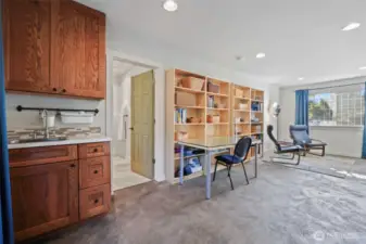 Counter with sink and cabinets in the corner could be added to if a kitchenette for ADU is desired. The bookshelves can stay.