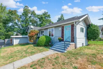 With steps leading up to the front porch and mature landscaping, this home blends vintage character with inviting curb appeal.