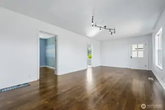 A versatile living space accented by modern track lighting, with direct flow into the dining area and bedrooms.