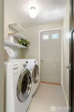 Utility Room, but on MAIN LEVEL! For days when you must do laundry- Washer & dryer stay with the home. The door takes you out to the side deck.