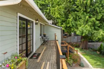 From the corner of the deck, lookiing back to the front of the house, and French doors off kitchen.  Homeowner just replaced all the spindles on the railings to update.