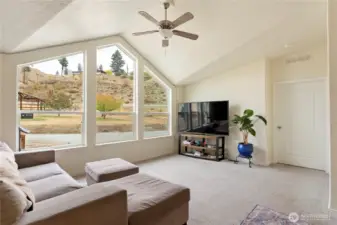 Vaulted ceilings in the living room, door to private primary suite.