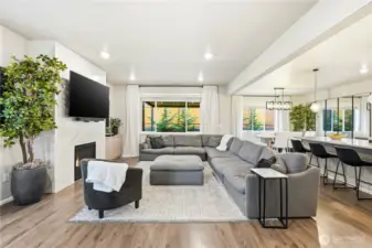Wide view of the main level showcasing the open concept layout connecting the kitchen, dining area, and great room.
