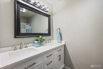Hallway has full bath with new vanity, featuring double sinks.