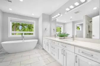 Tiled and heated floors, oversized double vanity and a soaking tub with a view of the trees.
