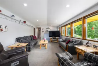 View from formal dining to the living room with cathedral ceiling and entry.