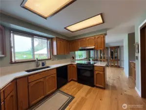 Another view of gorgeous kitchen with large fridge and stunning, durable hickory flooring.