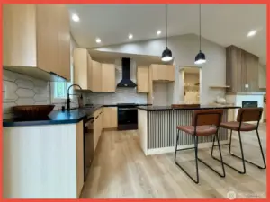 The kitchen features gorgeous cabs, stainless appliances, Quartz slab countertops, tiled backsplash and island/breakfast bar.