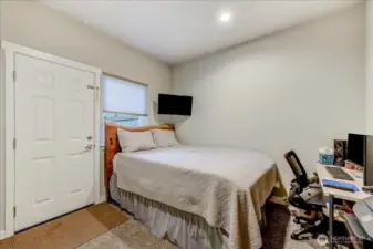 This lower-level bedroom has a closet (not pictured) and a door to the patio & fenced backyard.  Would make a great office or guest room, as it is currently being used as.