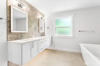 Primary bath offers extensive tile, heated floors, floating vanities, back lit mirrors, soaking tub, huge shower, and custom closet.