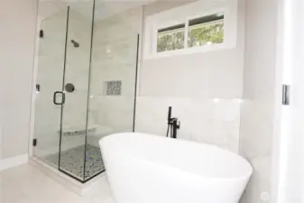 The primary bath has a soaking tub with glass enclosed shower.