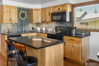 Gorgeous ceramic tile backsplash complements the granite countertops beautifully.