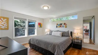 The en-suite primary bedroom easily accommodates a king bed and just about any furniture for your clothing and personal items. The transom windows are a lovely addition to the space.