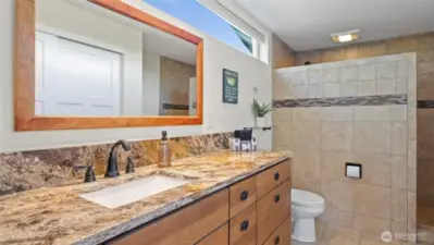 Natural stone slab counters, custom vanity cabinets and heated tile floors envelop you in the natural feel and coziness of the room.