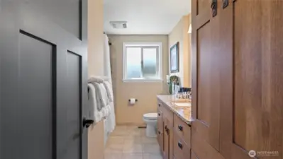 This full bath separates the primary from the second bedroom. Notice more of the beautiful cabinetry, including a floor-to-ceiling linen cabinet.