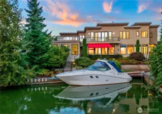 A beautiful look at the back of this majestic house. Direct from your dock through the canal to Lake Washington. House comes with the Yacht shown.