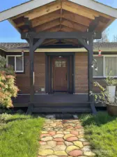 Covered portico and front deck makes for a graceful (and dry) entry to the home.