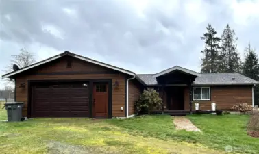 Front view of home, with covered entry portico as well as attached garage.