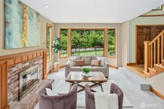 Spacious living room with wood burning fireplace off the dining room.