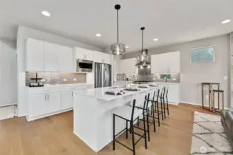 gorgeous kitchen with glass pendant lights, under cabinet lighting & ample storage.