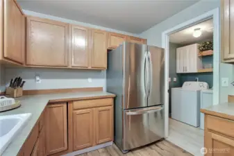 Kitchen view two, utility room off to your right with cabinet and storage, leads to your attached garage for a short grocery commute to your kitchen!