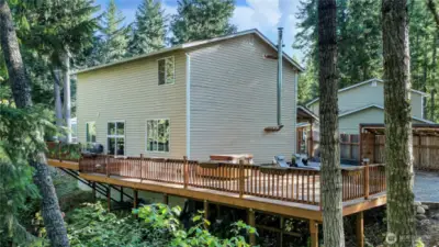 Drone view of the back of the home showing the massive decking and back/side yard.