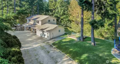 Drone view of the front of the property. Nice, long driveway off of a cul-de-sac with plenty of parking for you and your guests. Lovely front yard for playing, RV parking, beautiful setting!