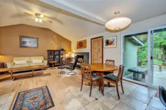 Another View Of The Family Room With Wood Burning Fireplace, Tiled Flooring And Slider To Backyard Oasis.