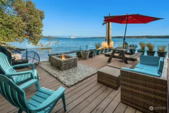 The eastern main-level deck with steps leading down to the beach, outdoor shower and loads of space to lounge.