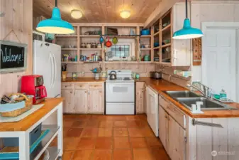 Full kitchen with open shelves, lots of storage and beautiful stained glass window.