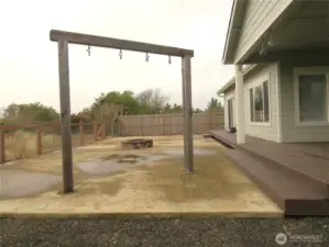 VIEW OF THE FENCED BACK YARD WITH PATIO AND SWINGS PLUS EASY CARE YARD!