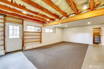 Partially finished room nest to the garage side of the basement.  Door on the left is a "greenhouse" being used to store lumber milled from the land.  Door on the right leads to a walk-in pantry/storage area.