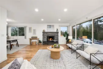 Spacious living room with a cozy fireplace and large picture windows filling this space with natural light.
