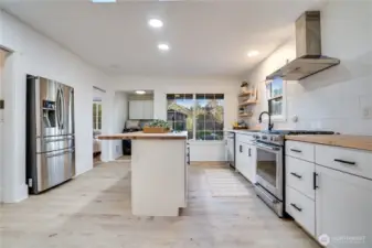 Open shelving and island storage provide everyday convenience, while the kitchen window looks out over the private backyard.
